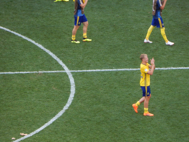Eine Gruppe von Fußballspielern in Uniformen, die auf einem Feld klatschen.