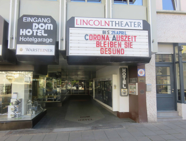 Außenansicht des Lincoln Theaters in Berlin, Deutschland, mit Glasfenstern und -türen, einem Schild mit Text und einem durch die Fenster sichtbaren Innenraum mit verschiedenen Gegenständen.