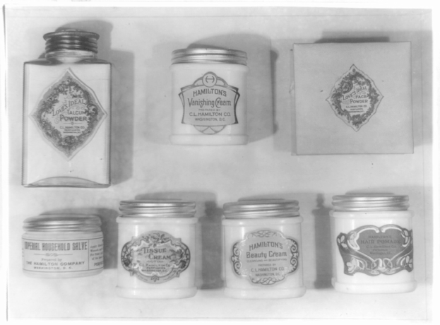 Schwarzes und weißes Foto eines Regals mit ordentlich angeordneten Cremetöpfchen, jedes mit verschiedenen Typen beschriftet.