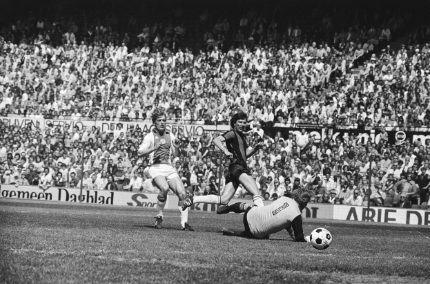 Schwarzes und weißes Foto von Fußballspielern im Einsatz auf einem Feld mit Zuschauern im Hintergrund und einer Tafel mit der Aufschrift "Bundesliga 1978-79 Ajax 1-1 Hannover 96."