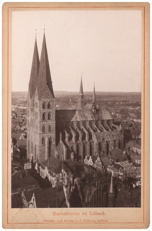 Schwarz-weiß-Fotografie einer Stadtansicht mit einer prominenten Kirche in der Mitte, umgeben von verschiedenen Gebäuden, und Text am unteren Rand.