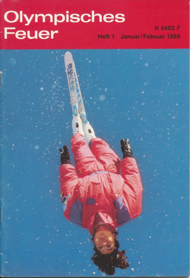 Ein Buchumschlag mit einem Skifahrer in der Luft, der eine Skiuniform trägt, und der Text "Olympische Spiele Feuer - Heft 1 - Januar/Februar 1988" deutlich zu erkennen ist.