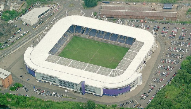 Luftaufnahme des Stadions von Tottenham Hotspur Football Club in einer städtischen Umgebung, umgeben von Gebäuden, Bäumen und Straßen mit Fahrzeugen.