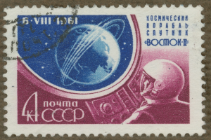 Eine Briefmarke mit einem Mann im Weltraumanzug mit entschlossener Miene, umgeben von der Textzeile "Marke" in fetter, weißer Schrift.