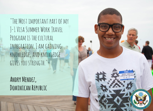 Ein Mensch in einem weißen T-Shirt lächelt beim Spaziergang mit einer Gruppe auf einem Holzboden, mit einem Zitat über kulturelle Integration von Andry Mendez auf der linken Seite, Gebäuden und einem klaren blauen Himmel im Hintergrund.